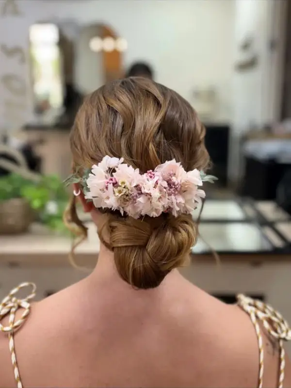 Moño bajo con flores rosas, visto de espaldas